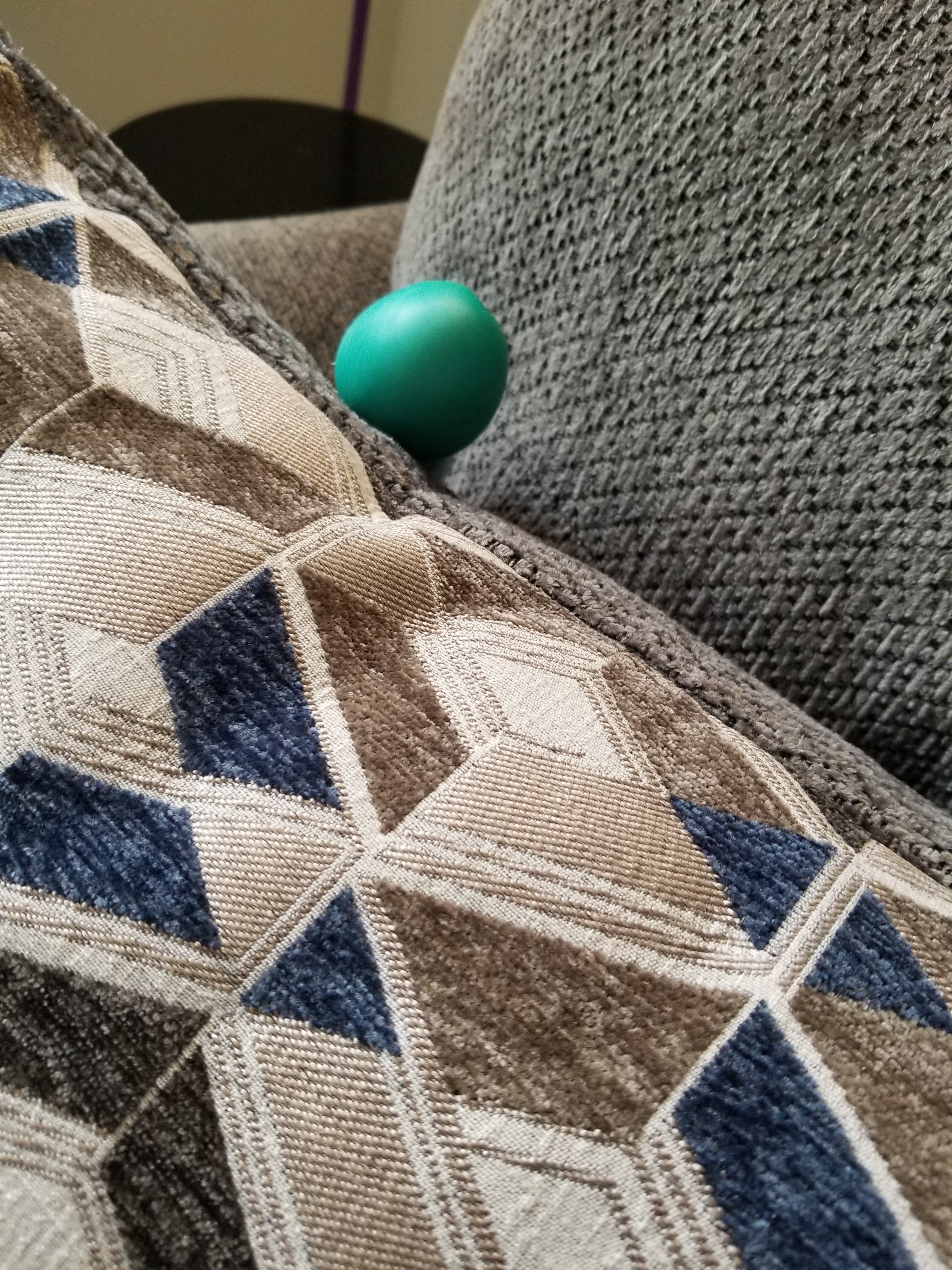Big Blue hiding behind a pillow on the couch