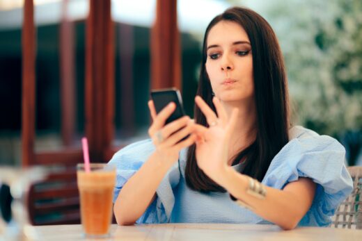 Woman swiping on dating app looking frustrated